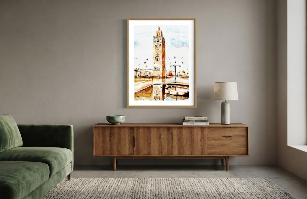 Tableau encadré de l'aquarelle « La Gardienne de Marrakech », accroché au mur au-dessus d'un meuble en bois bas dans un salon moderne aux teintes neutres.