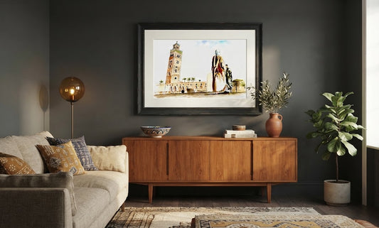 Tableau encadré de l'aquarelle « Contemplation de la Koutoubia », accroché au mur au-dessus d'un meuble en bois dans un salon moderne aux tons sombres.