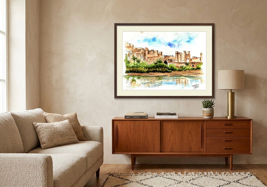 Tableau encadré représentant l'aquarelle Ksar Aït-ben-Haddou, accroché au-dessus d'un meuble en bois dans un salon moderne.
