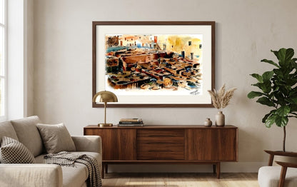 Tableau encadré représentant l'aquarelle des tanneries de Fès, accroché au-dessus d'un buffet en bois dans un salon moderne.