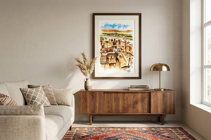 Tableau encadré représentant l'aquarelle Thé à la Kasbah, accroché au-dessus d'un buffet en bois dans un salon lumineux.